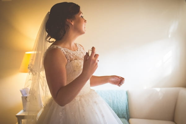 Bride putting perfume on