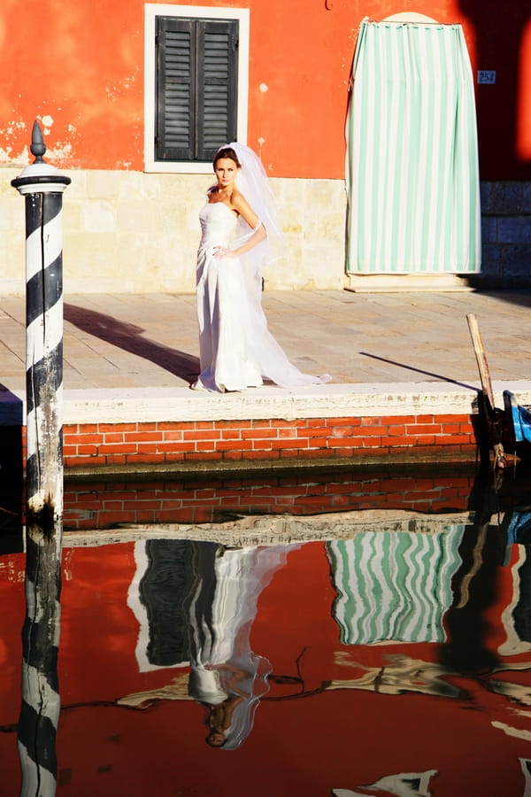 Bride standing by canal in Venice