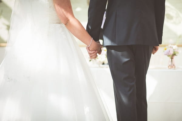 Bride and groom holding hands at altar