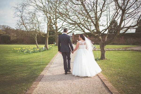 Bride and groom walking holding hands