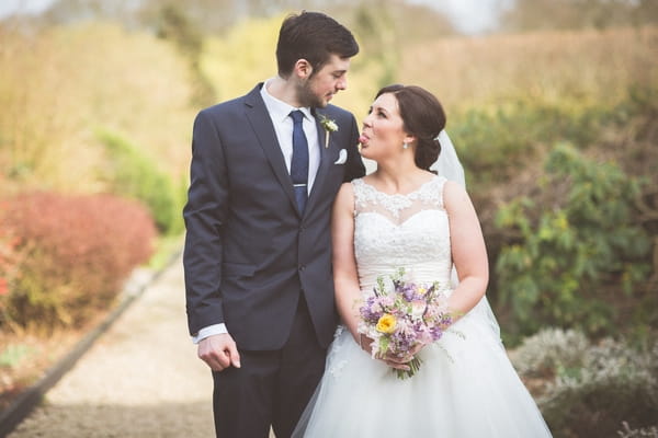 Bride sticking tongue out at groom