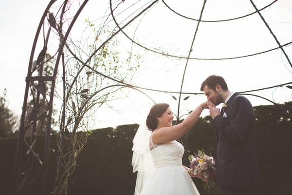 Groom kissing bride's hand