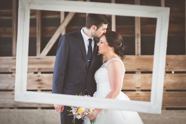 Groom kissing bride on the head