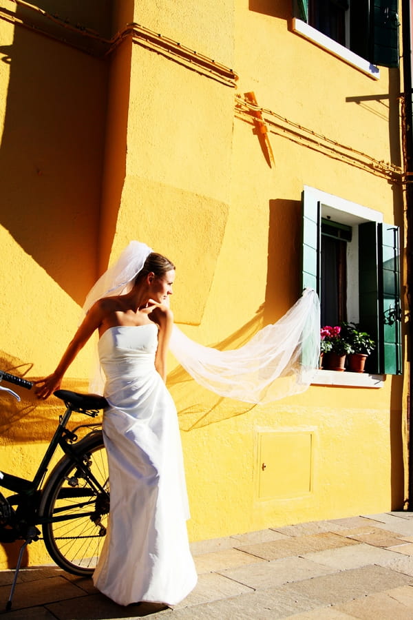 Bride with veil caught in window shutter