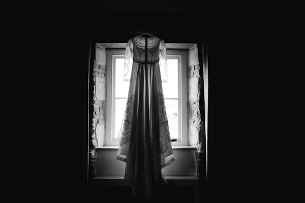 Wedding dress hanging in window