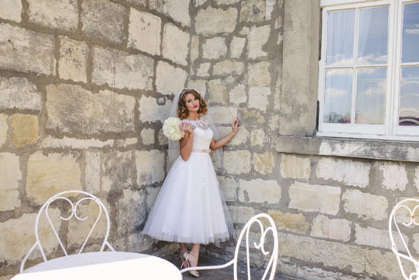 1950s bride next to wall