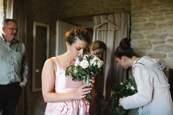 Bridesmaid smelling bouquet