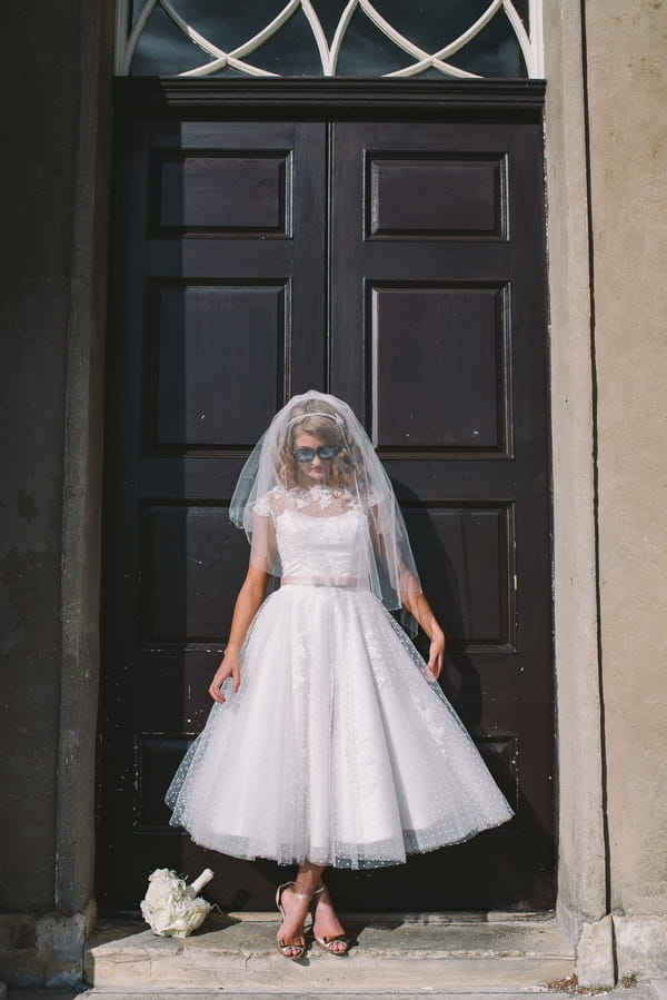 1950s bride in front of door