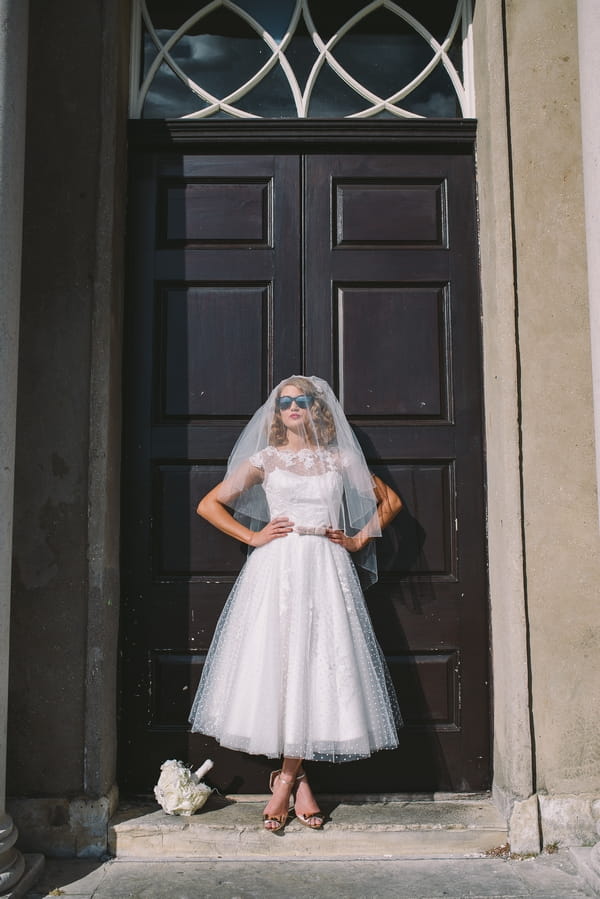 1950s bride in front of door