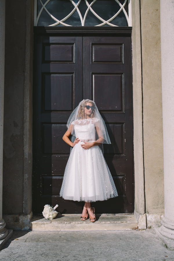 1950s bride in front of door