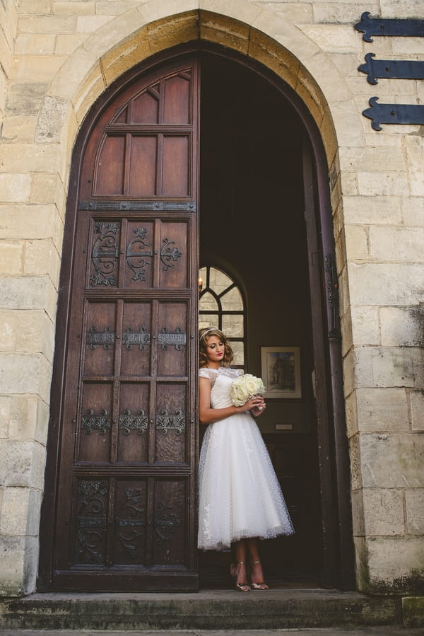 1950s bride standing by open door