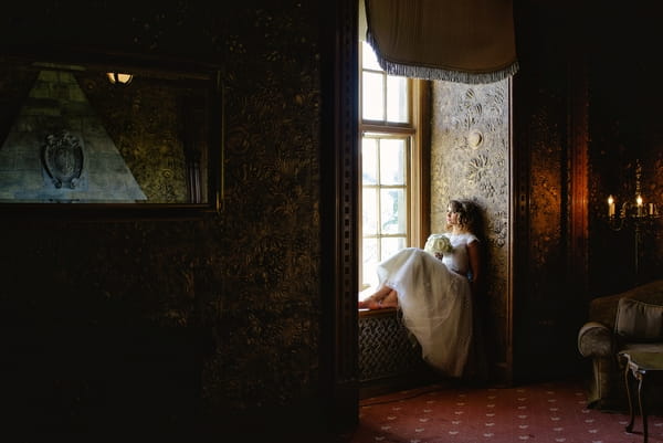 1950s bride sitting on window ledge