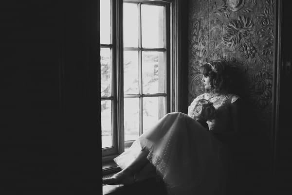 1950s bride sitting on window ledge