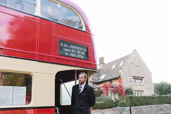 Man on back of red bus