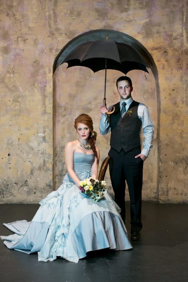 Bride and groom under umbrella