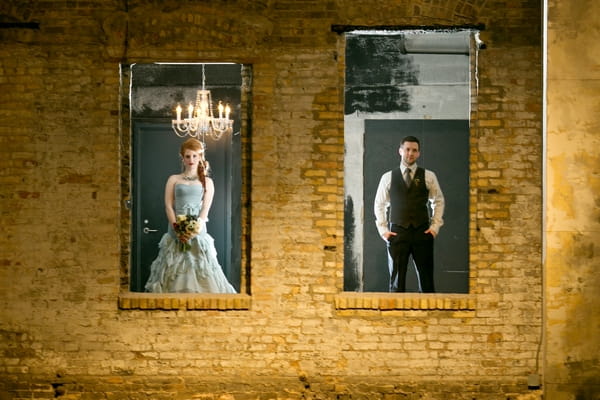 Bride and groom standing behind wall