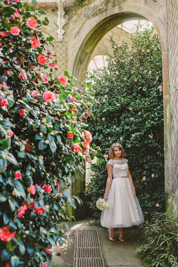 1950s bride standing amongst trees