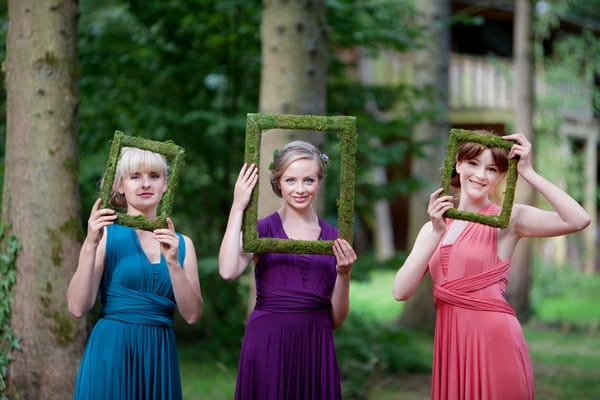 Bridesmaids holding picture frames in front of faces