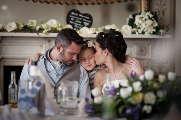 Young girl hugging bride nd groom - Picture by Linus Moran Photography