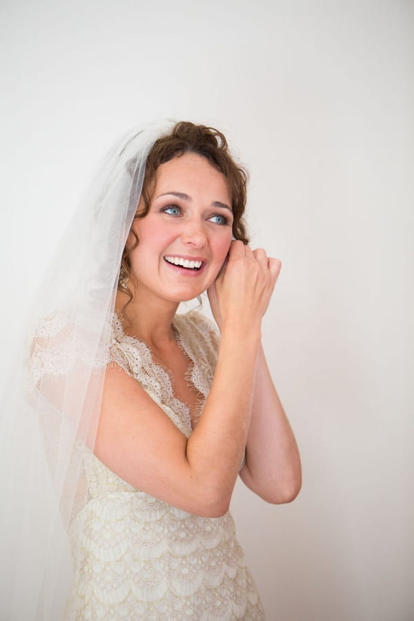 Bride putting on earring