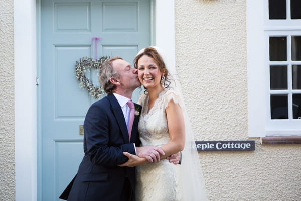 Father kissing bride on cheek