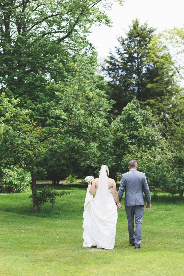 Bride and groom walking in gardens of Deer Park Country House Hotel