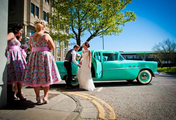 Bride getting out of wedding car