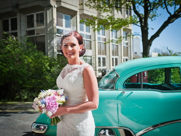 Bride next to wedding car