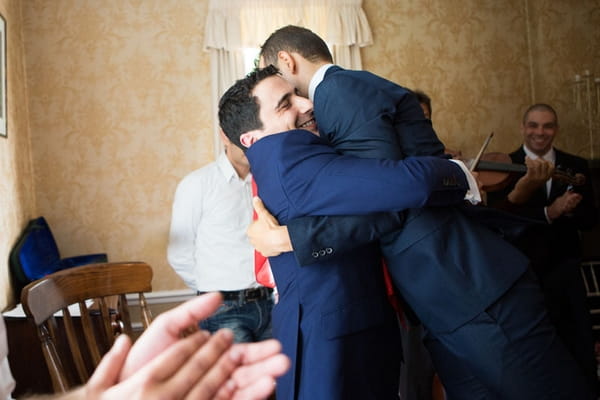 Groom lifting up man