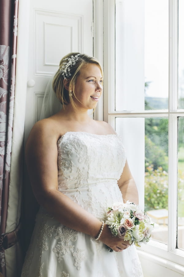 Bride standing by window