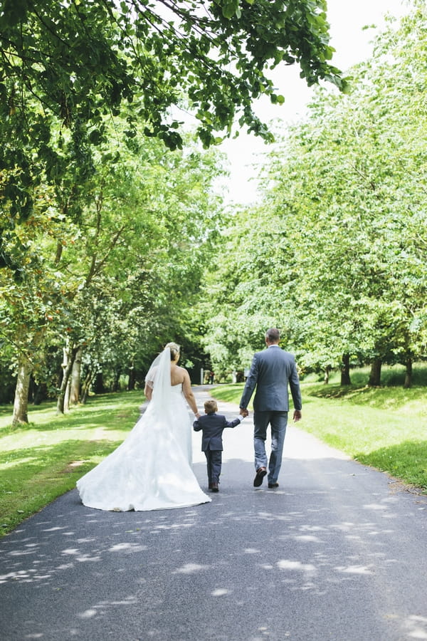 Bride and groom walking with son