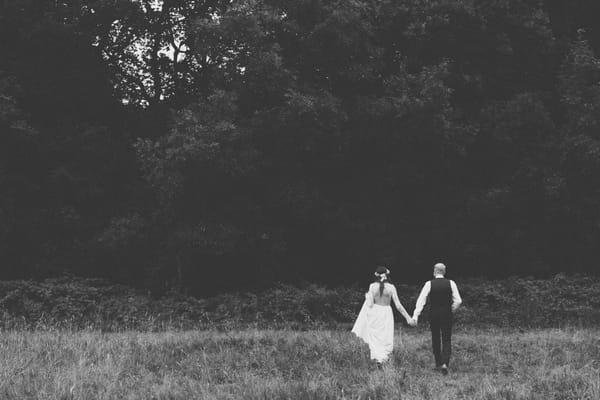 Bride and groom walking to woods