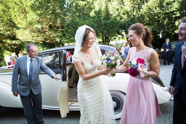 Bride and bridesmaid outside of wedding car