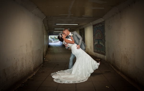 Bride and groom kissing in subway