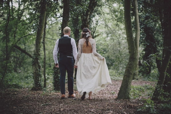 Bride and groom walking in woods