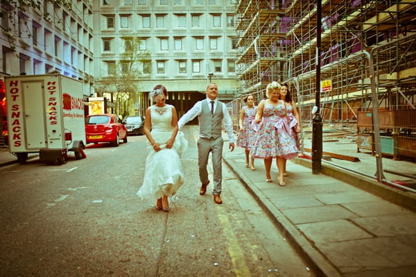 Bride and groom walking with bridesmaids