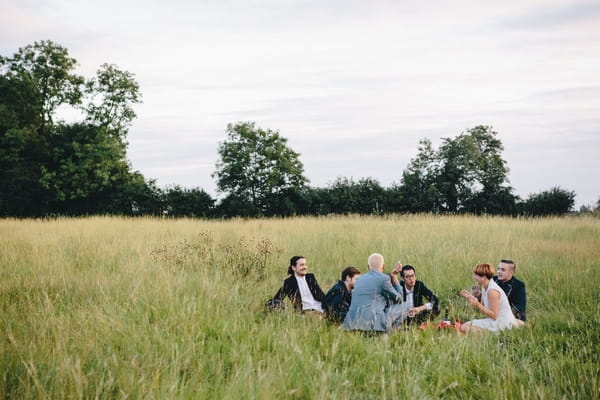 Wedding guests sitting in field