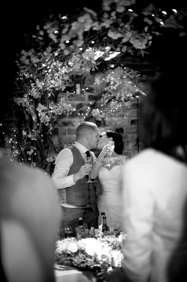 Bride and groom kissing during toast