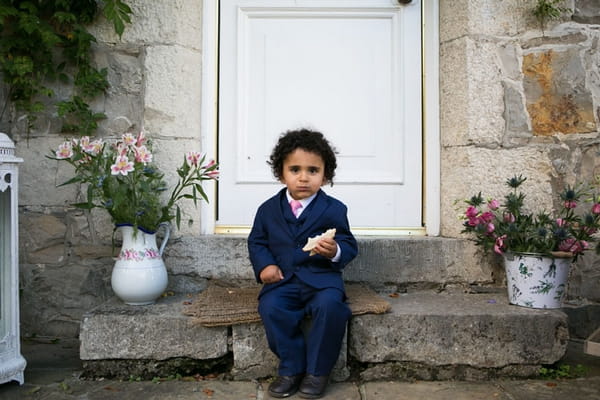 Small boy sitting on step eating sandwich