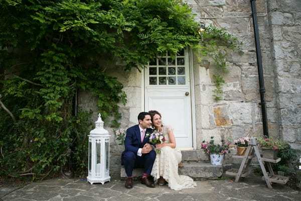 Bride and groom sitting on step