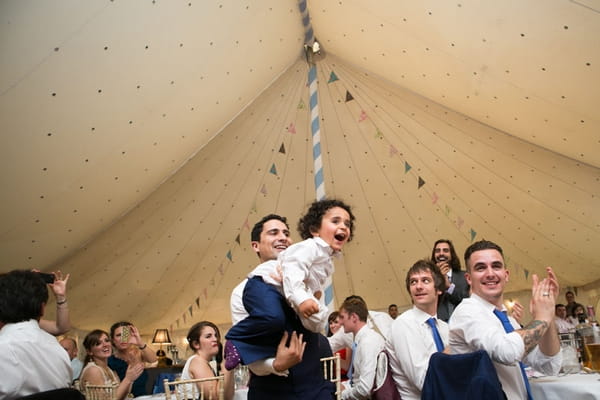 Groom lifting up young boy