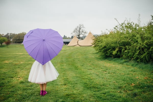 Bride holding purple heart umbrella