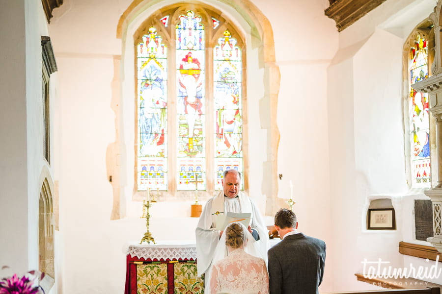 Bride and groom kneeling at altar