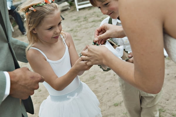 Flower girl giving wedding rings to bride