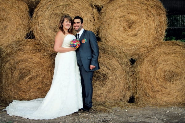Bride and groom in front of hay bales - Picture by Twirly Girl Photography