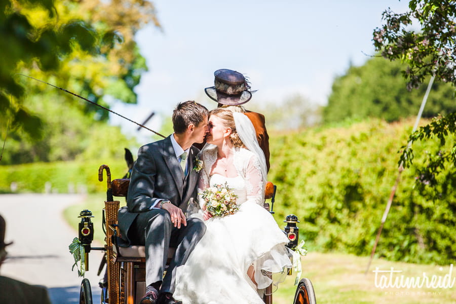 Bride and groom kissing on horse and cart