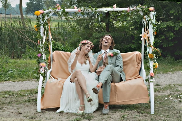 Bride and groom sitting on rocking bench