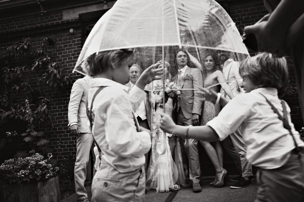 Wedding picture being taken behind umbrella