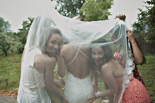 Bride and bridesmaids under veil