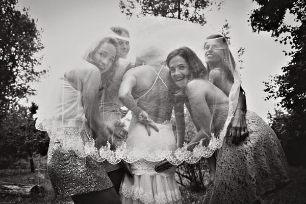 Bride and bridesmaids under veil